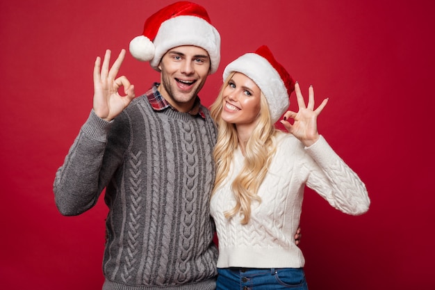 Portrait of a cheerful young couple in christmas hats