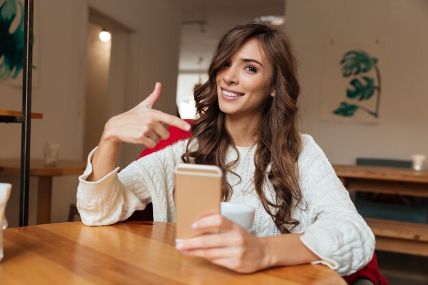 Portrait of a cheery woman pointing finger