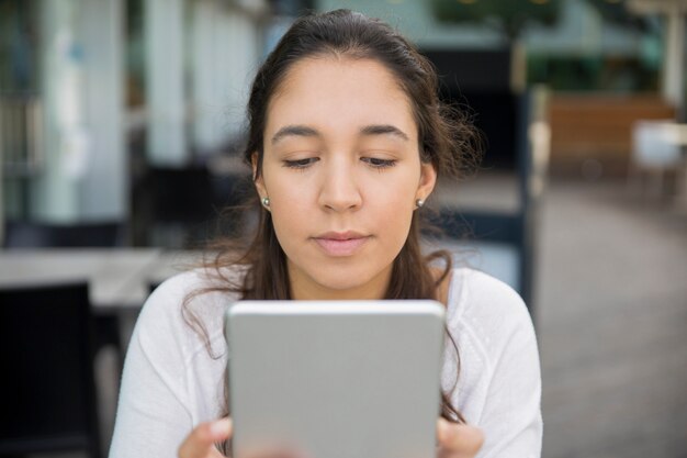 Portrait of concentrated teenage girl networking on pc tablet