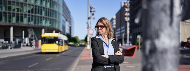 Free photo portrait of confident business woman in suit cross arms on chest looking selfassured in city center