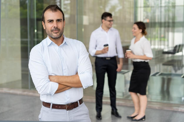 Portrait of confident mid adult leader standing with folded arms