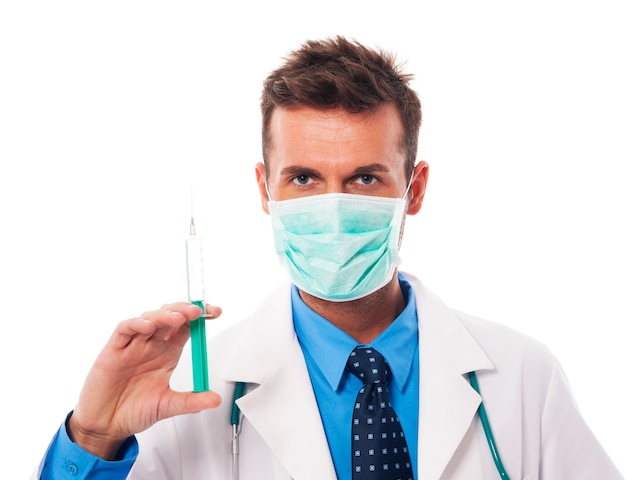 Portrait of confident surgeon holding syringe