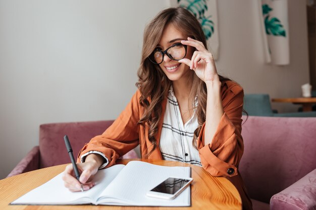 Portrait of a confident woman taking notes