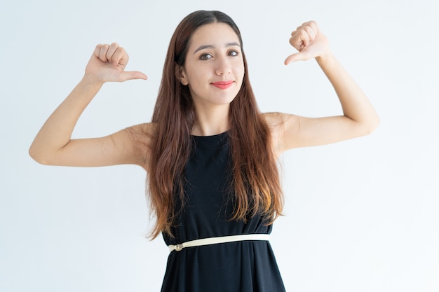 Portrait of confident young businesswoman pointing at herself