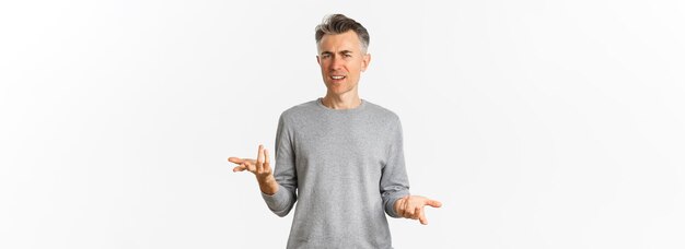 Portrait of confused and disappointed middleaged man arguing cant understand something and asking why standing over white background perplexed