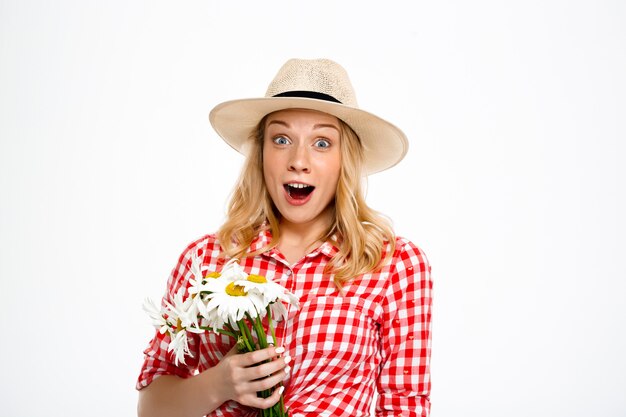 Portrait of country woman with chamomiles on white.