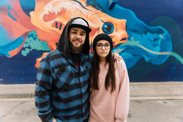 Portrait of a couple in front of graffiti wall