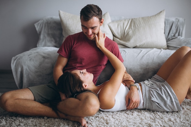 Portrait of couple at home together sitting on floor by the couch