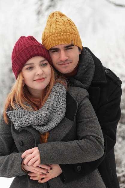 Portrait of couple hugging outdoors in winter season