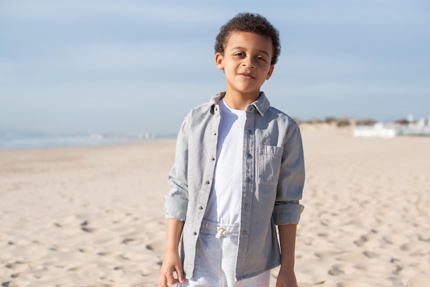 Portrait of cute African American boy on beach