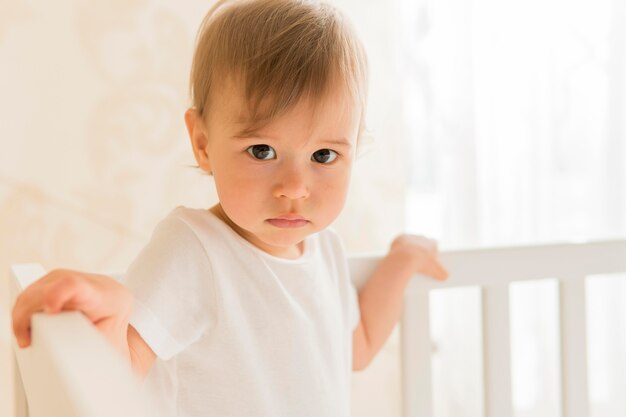 Portrait of cute baby in crib