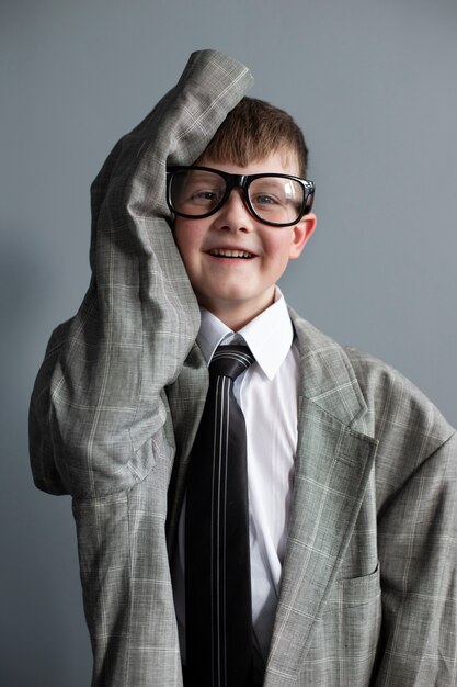 Portrait of cute child with oversized suit and glasses