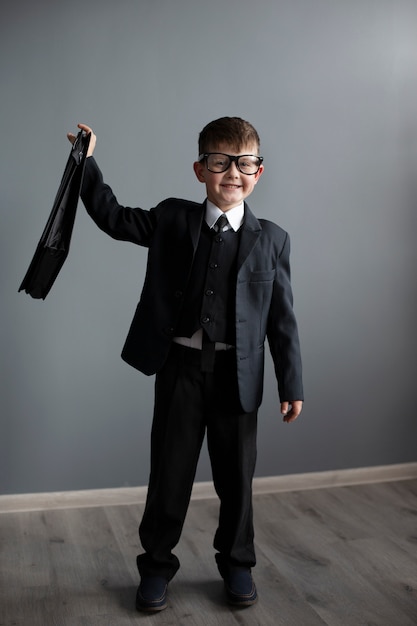 Free photo portrait of cute child with suit and briefcase