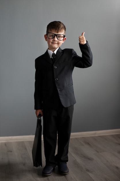 Free photo portrait of cute child with suit and briefcase