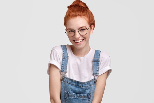 Portrait of cute ginger woman in overalls