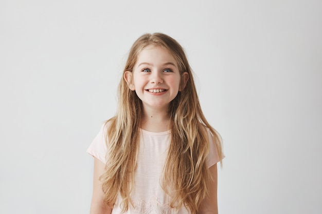 Free Photo portrait of cute little girl with long light hair smiling  looking upside on colorful flying balloons with happy and excited expression.