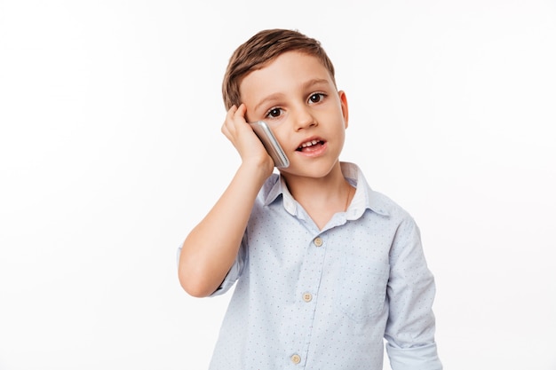 Portrait of a cute little kid talking on mobile phone