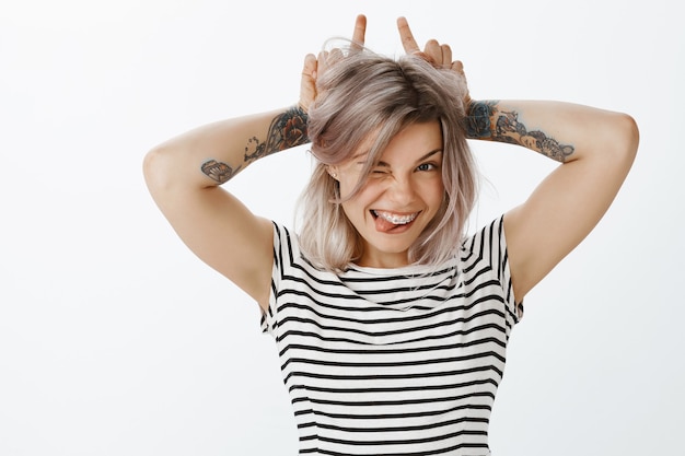 Free photo portrait of cute playful blonde girl posing in the studio