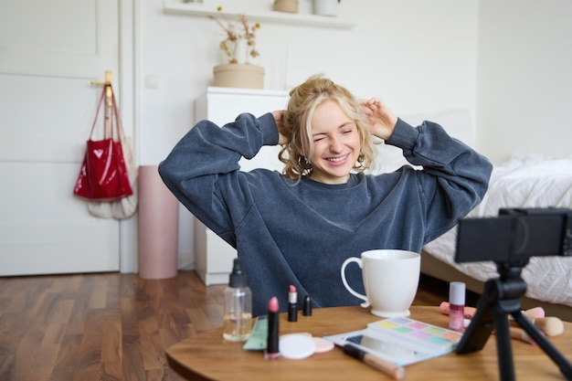 Free Photo portrait of cute smiling woman blond girl drinks tea and records a casual lifestyle video blog