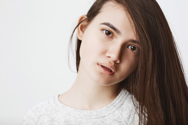 Portrait of cute teenage woman with hair on one side looking frustrated and tired