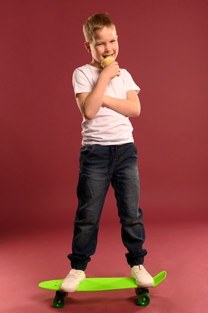 Free Photo portrait of cute young boy posing with skateboard