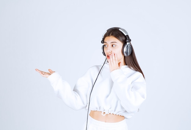 Portrait of a cute young girl model standing with headphones