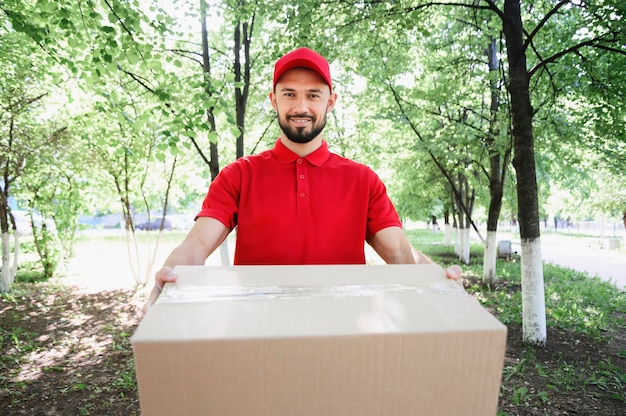 Free photo portrait of delivery man handing out parcel