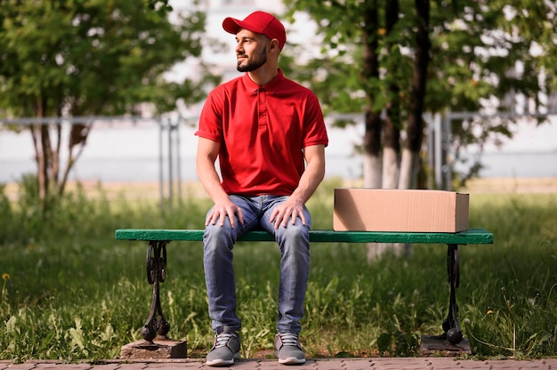 Portrait of delivery man sitting on a bench