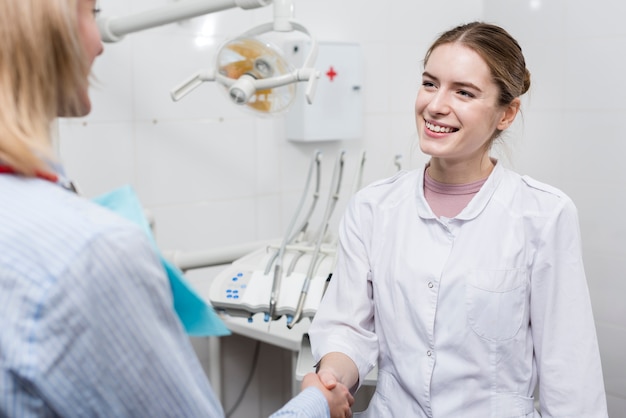 Portrait of dentist shaking hand with patient