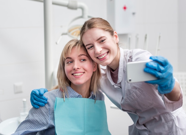 Free photo portrait of dentist taking a selfie with patient