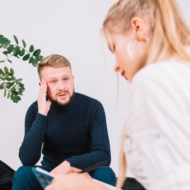 Free photo portrait of depressed male patient talking with female psychologist