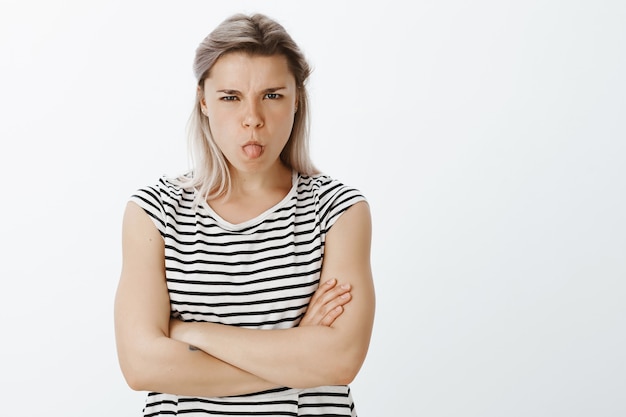 Portrait of disobedient blonde girl posing in the studio