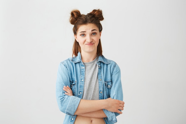 Free photo portrait of displeased young girl with buns . crossed arms.