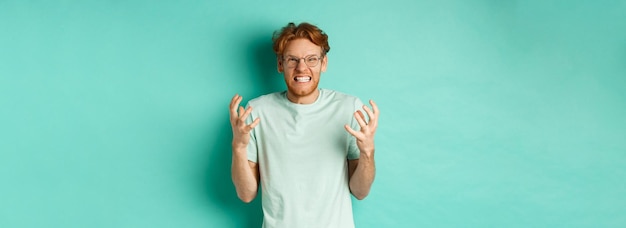 Free photo portrait of distressed and angry redhead guy losing temper shouting and shaking hands outraged stari