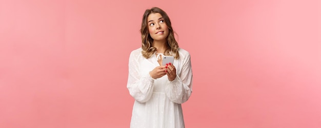 Portrait of dreamy and thoughtful girl thinking what order using application to make reservation loo