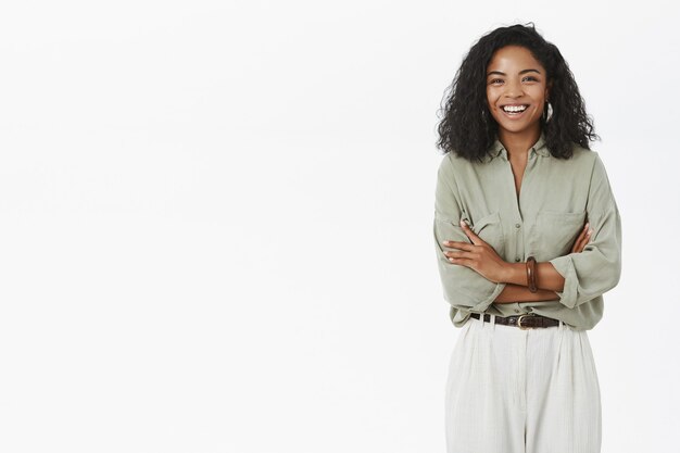 Portrait of enthusiastic delighted adult dark-skinned woman with curly haircut