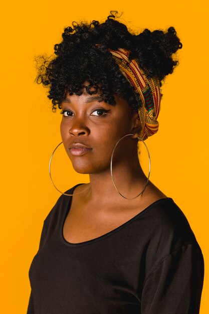 Portrait of ethnic curly young woman on colored background