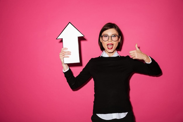 Free photo portrait of an excited happy businesswoman with arrow pointing up