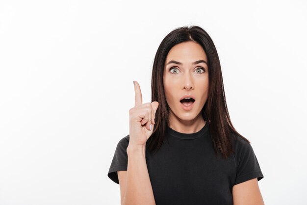 Portrait of an excited woman poiting finger up