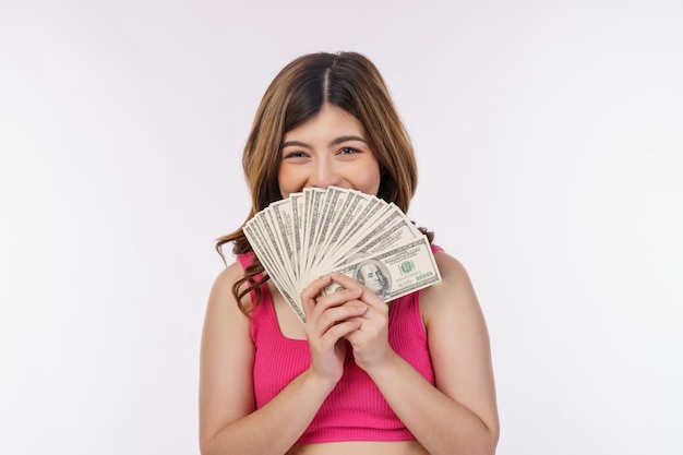 Portrait of excited young woman holding bunch of dollars banknotes isolated over white background