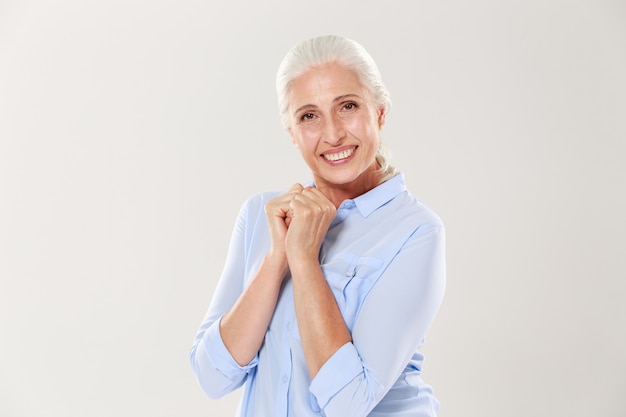 Portrait of exited old woman in blue shirt