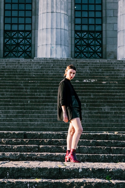 Portrait of a fashion young woman standing on staircase