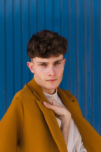 Portrait of fashionable boy against blue wall