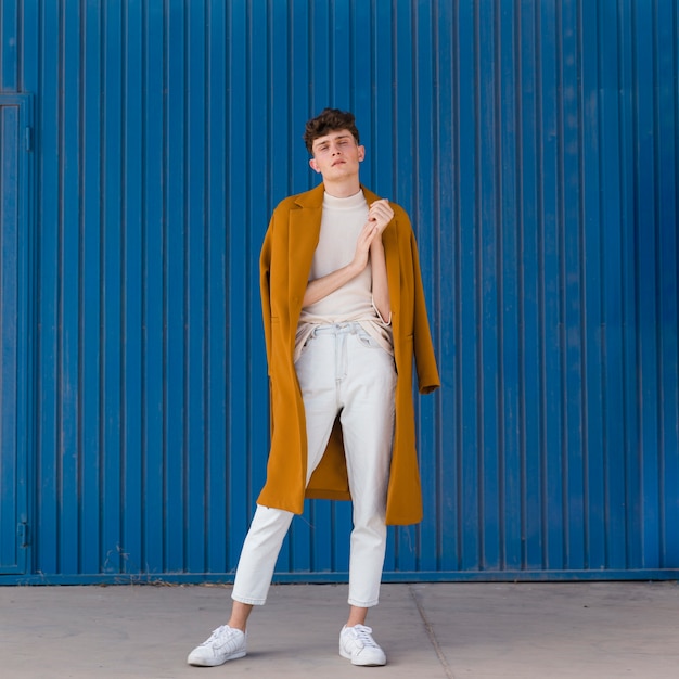 Portrait of fashionable boy against blue wall