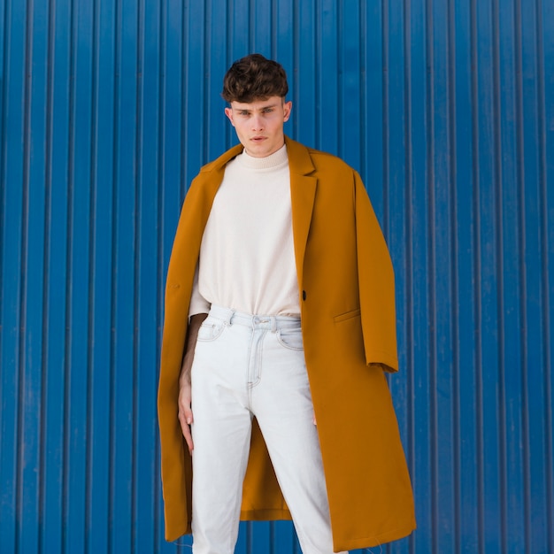 Portrait of fashionable boy against blue wall