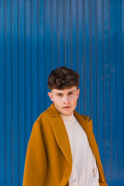 Portrait of fashionable boy against blue wall