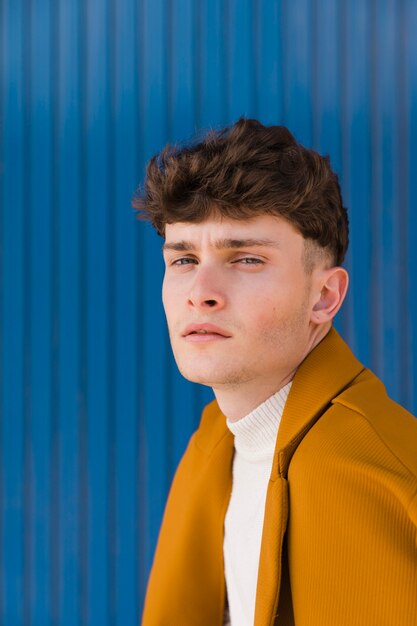 Portrait of fashionable boy against blue wall