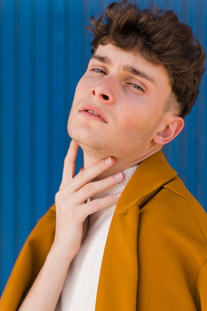 Portrait of fashionable boy against blue wall