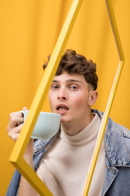 Portrait of fashionable boy drinking within a frame