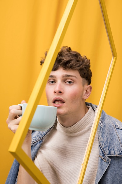 Portrait of fashionable boy drinking within a frame